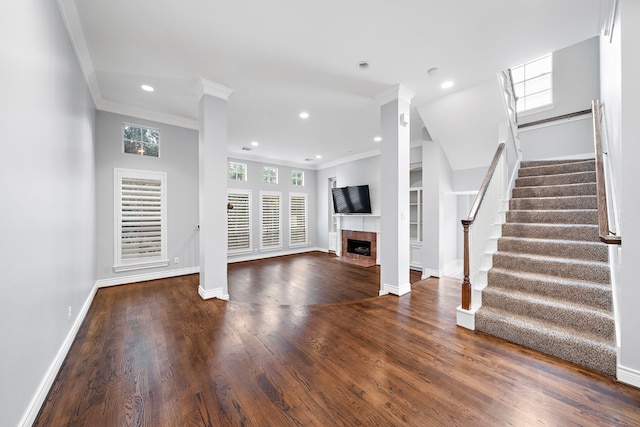 unfurnished living room featuring dark wood-type flooring, built in features, ornamental molding, and a tile fireplace