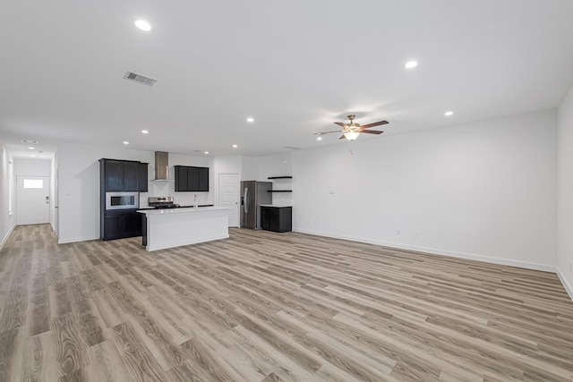 unfurnished living room featuring ceiling fan and light hardwood / wood-style floors