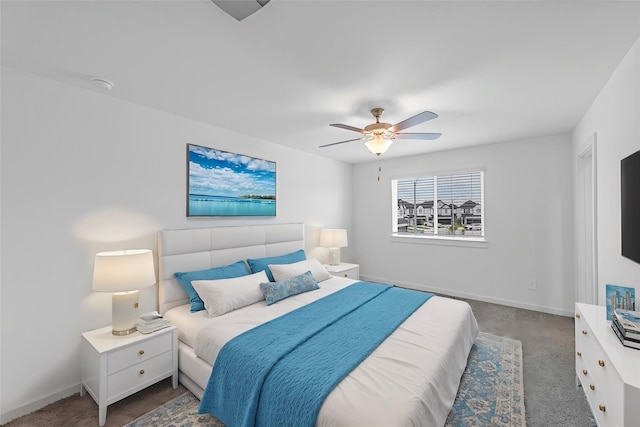 bedroom with ceiling fan and dark colored carpet