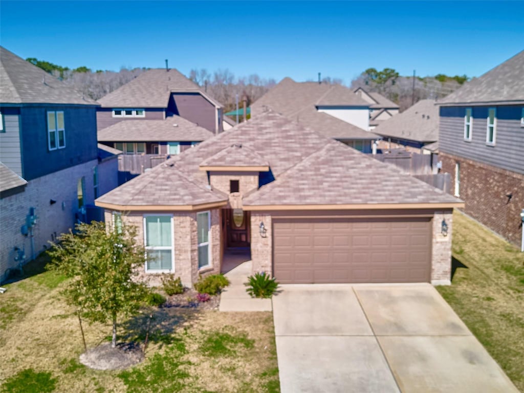 view of property featuring a garage and a front lawn