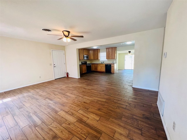 unfurnished living room featuring dark hardwood / wood-style flooring and ceiling fan