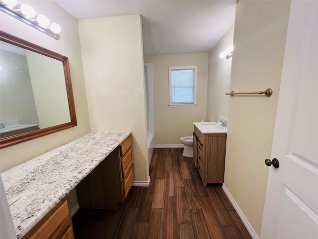 bathroom with hardwood / wood-style flooring, vanity, and toilet