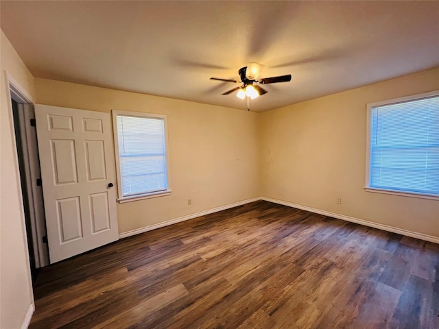 spare room featuring dark hardwood / wood-style flooring, plenty of natural light, and ceiling fan