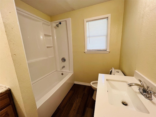 full bathroom with vanity, wood-type flooring, toilet, and washtub / shower combination