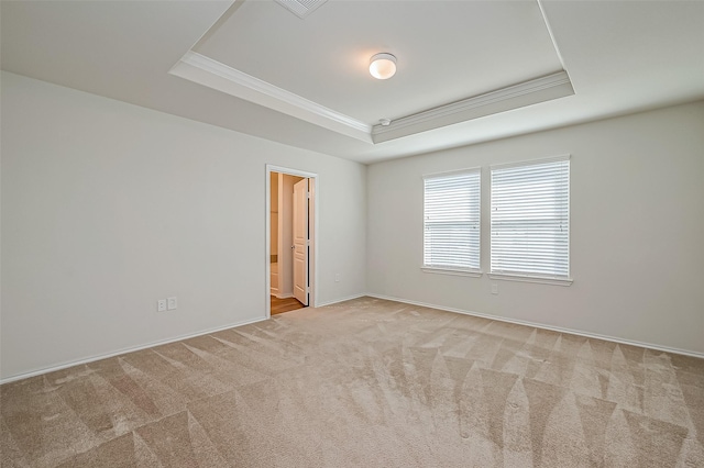 unfurnished room featuring ornamental molding, light colored carpet, and a tray ceiling