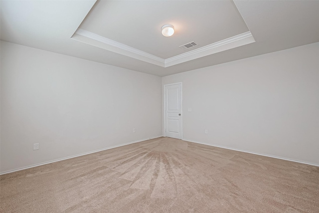 unfurnished room featuring visible vents, light colored carpet, crown molding, and a raised ceiling