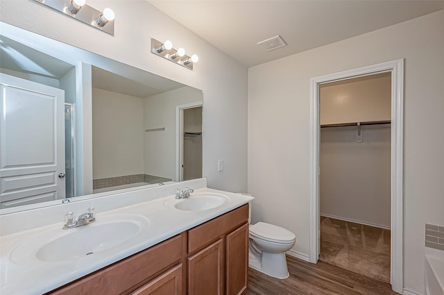 bathroom featuring vanity, toilet, hardwood / wood-style floors, and a tub