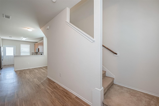 stairway with hardwood / wood-style floors