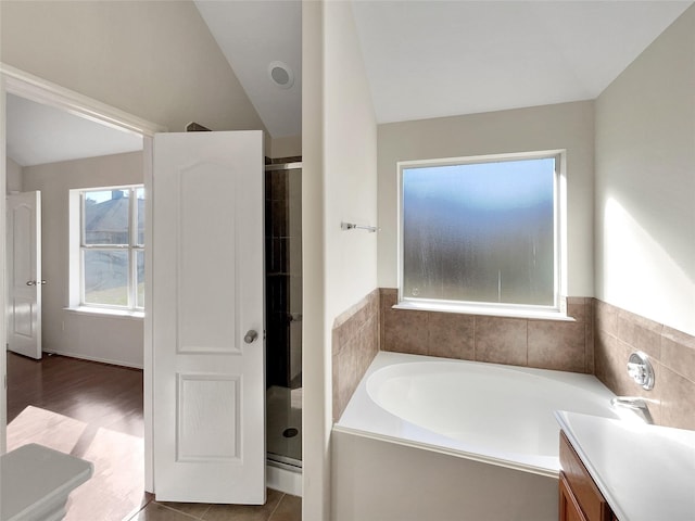 bathroom featuring lofted ceiling, vanity, and separate shower and tub