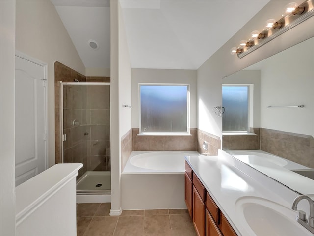 bathroom featuring tile patterned floors, separate shower and tub, vaulted ceiling, and vanity