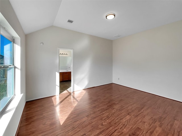 unfurnished room featuring hardwood / wood-style flooring and lofted ceiling