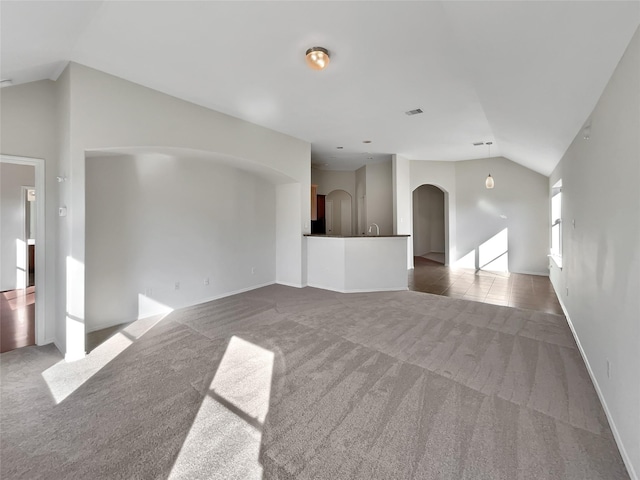 unfurnished living room featuring lofted ceiling and carpet floors