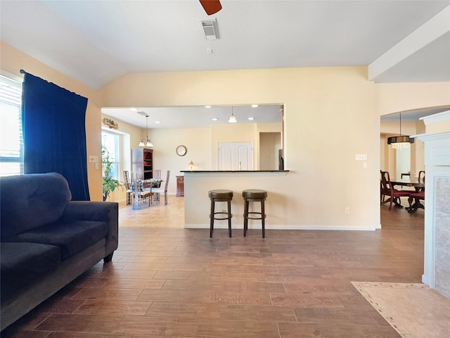 living room featuring wood-type flooring, lofted ceiling, and ceiling fan