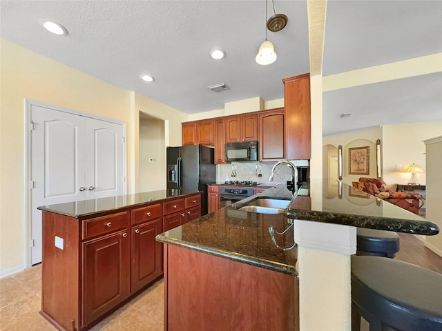 kitchen featuring sink, black appliances, hanging light fixtures, kitchen peninsula, and backsplash