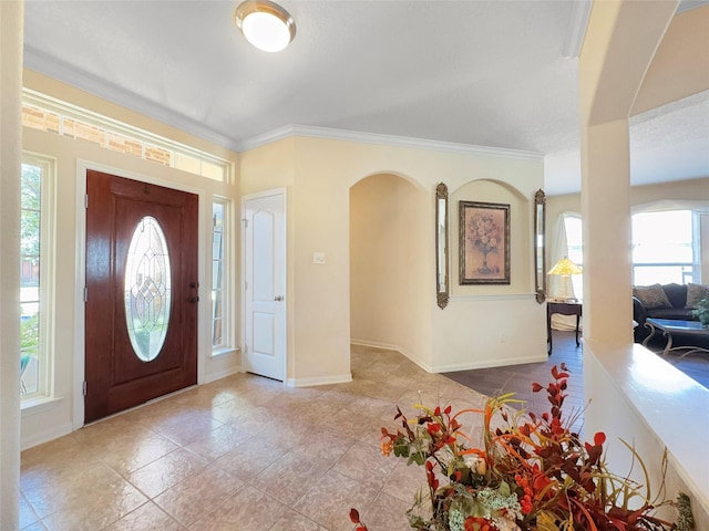 entrance foyer with light tile patterned floors and crown molding