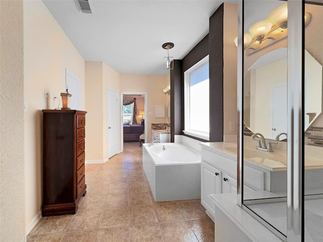 bathroom featuring a tub to relax in, vanity, and tile patterned floors