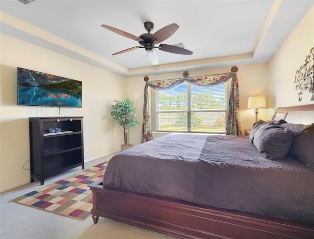 bedroom featuring ceiling fan, carpet flooring, and a raised ceiling