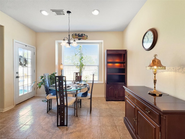 dining space featuring an inviting chandelier, light tile patterned floors, and a wealth of natural light