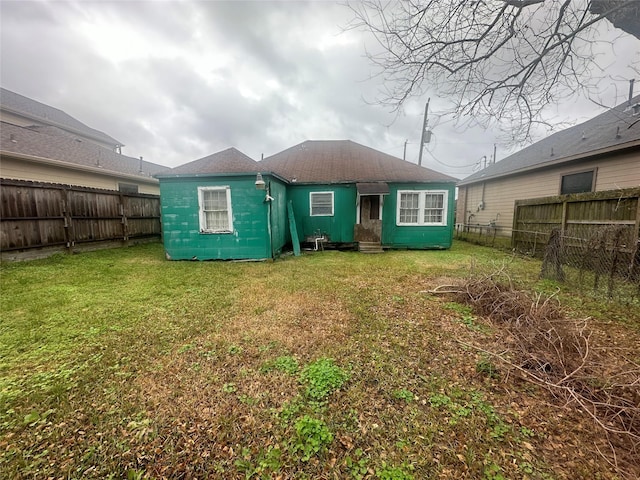 rear view of property with a lawn