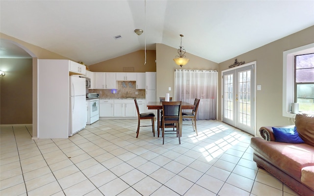 dining area with light tile patterned floors, sink, vaulted ceiling, and french doors