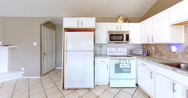 kitchen featuring tasteful backsplash, light tile patterned floors, white cabinets, and white appliances