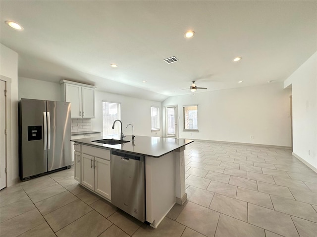 kitchen with sink, a center island with sink, light tile patterned floors, stainless steel appliances, and white cabinets