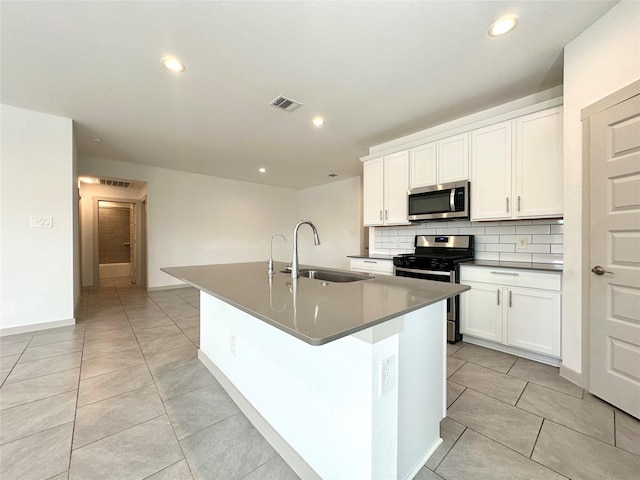 kitchen featuring white cabinetry, appliances with stainless steel finishes, sink, and an island with sink