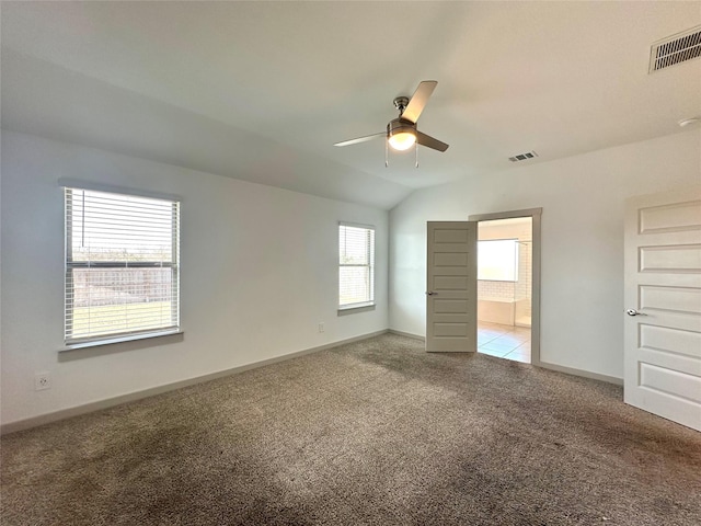 unfurnished bedroom featuring ceiling fan, lofted ceiling, carpet flooring, and ensuite bathroom