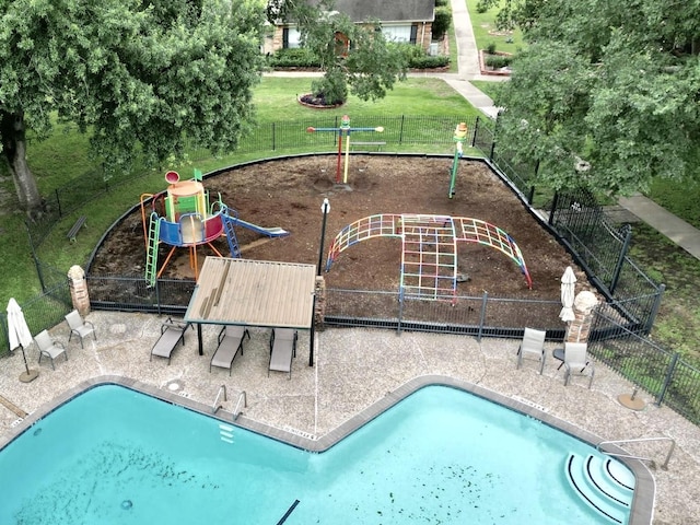 view of swimming pool with a lawn and a playground