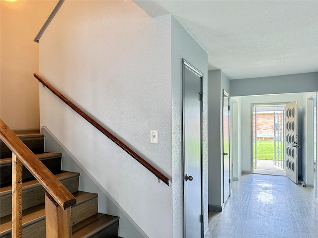 staircase with a textured ceiling