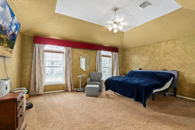 bedroom featuring ceiling fan, carpet floors, a textured ceiling, vaulted ceiling, and a raised ceiling