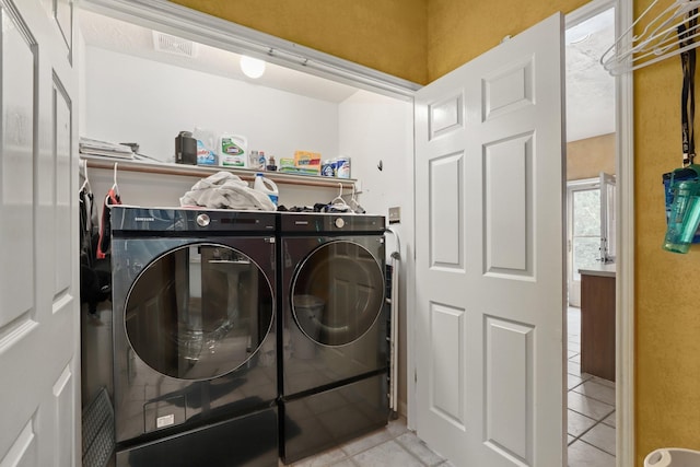 washroom featuring light tile patterned floors and washing machine and dryer