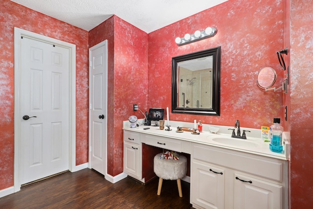 bathroom with hardwood / wood-style flooring, vanity, and a textured ceiling