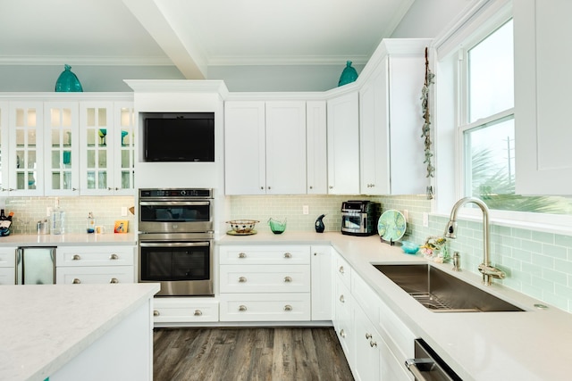 kitchen featuring appliances with stainless steel finishes, dark hardwood / wood-style floors, sink, and white cabinets