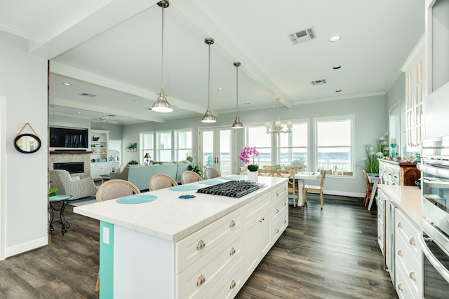 kitchen with dark hardwood / wood-style floors, oven, white cabinets, hanging light fixtures, and a center island