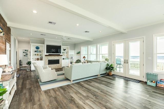 living room with wood-type flooring, ornamental molding, french doors, and beamed ceiling