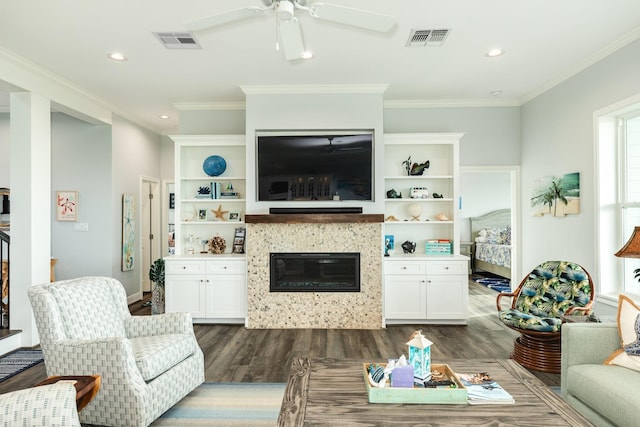 living room featuring crown molding, dark hardwood / wood-style floors, ceiling fan, and a fireplace