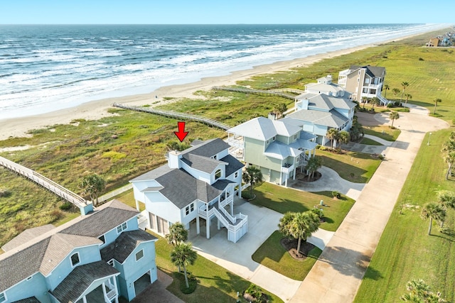 birds eye view of property with a water view and a view of the beach