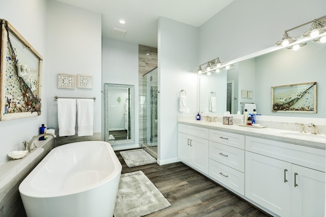 bathroom featuring vanity, hardwood / wood-style flooring, and plus walk in shower