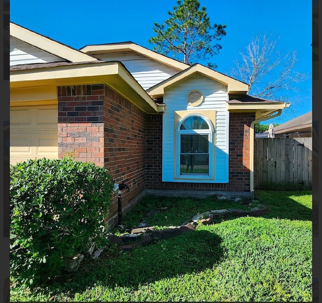 view of side of home featuring a garage and a lawn