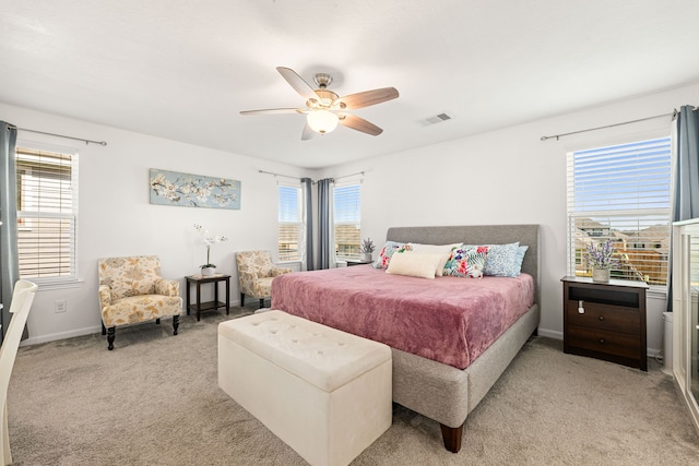 carpeted bedroom with multiple windows and ceiling fan