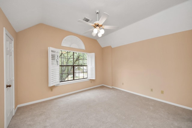 spare room featuring ceiling fan, light colored carpet, and lofted ceiling