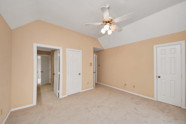 unfurnished bedroom featuring vaulted ceiling, light carpet, and ceiling fan