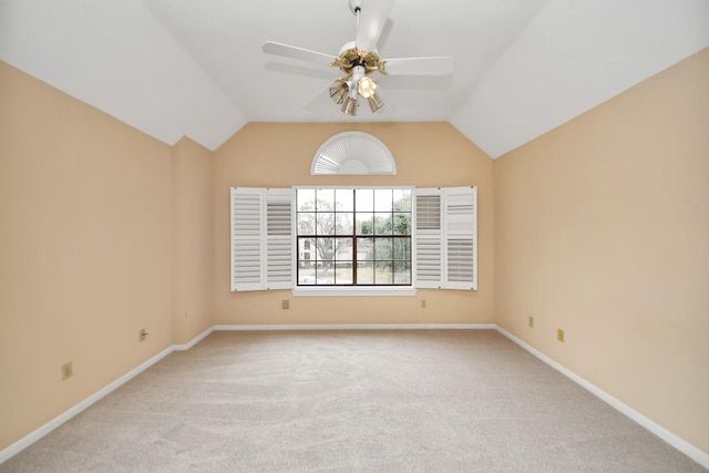 spare room with light carpet, vaulted ceiling, and ceiling fan