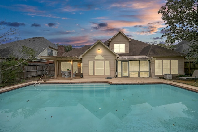 pool at dusk with a patio