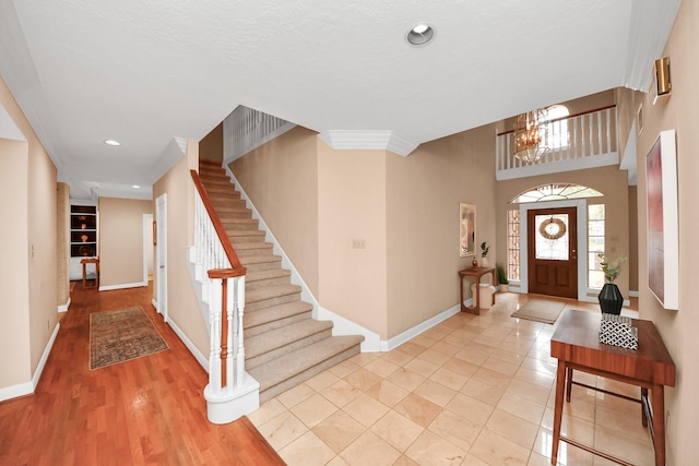 entrance foyer with ornamental molding and light tile patterned floors