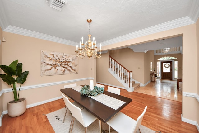 dining room with crown molding and light hardwood / wood-style floors