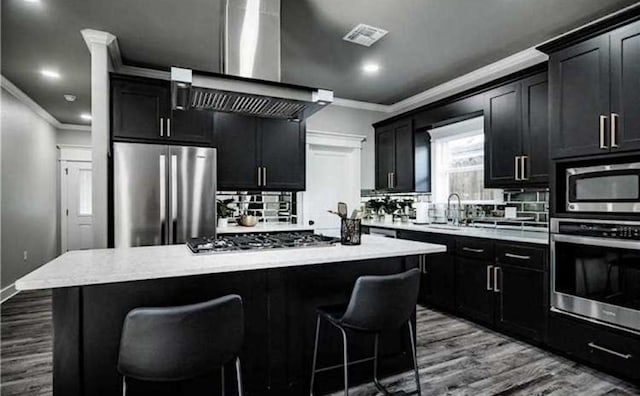 kitchen with stainless steel appliances, a center island, sink, and a kitchen breakfast bar