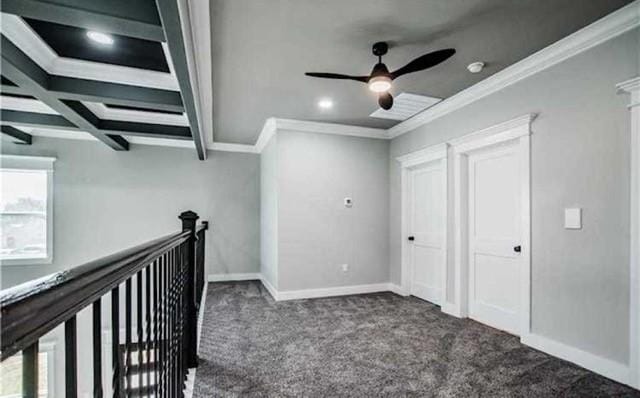 interior space featuring beam ceiling, ornamental molding, and dark carpet