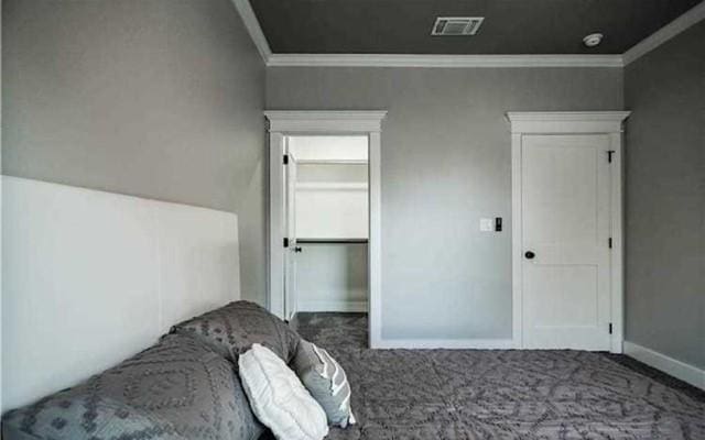 bedroom featuring ornamental molding and dark carpet